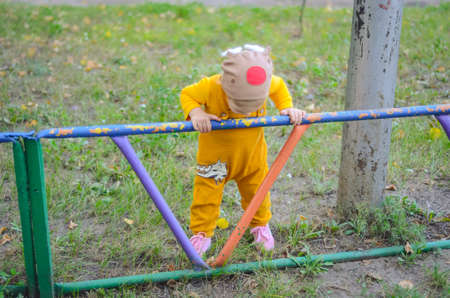 Photo of a blue-eyed toddler girl playing outside on the playgroundの写真素材
