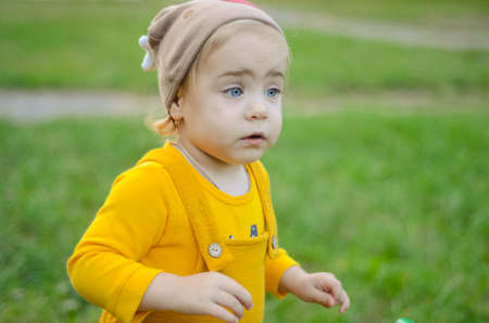 Photo of a blue-eyed toddler girl playing outside on the playgroundの写真素材