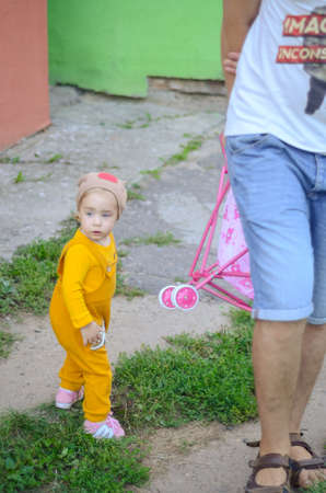 Photo of a blue-eyed toddler girl playing outside on the playgroundの写真素材