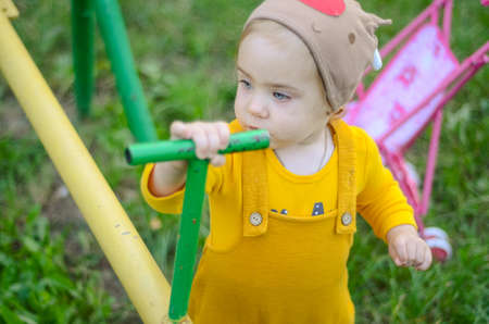 Photo of a blue-eyed toddler girl playing outside on the playgroundの写真素材