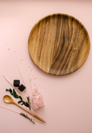 Close-up vertical Flat Lay SPA objects: sea salt, wooden spoons, white and pink shells, rose flowers buds and leaves, Wooden plate round mockup space for and textの写真素材