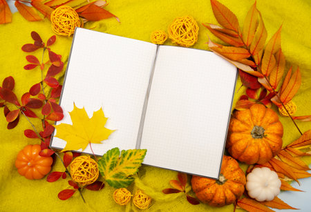 Autumn composition background knitted with workspace planner blank notebook, beautiful red yellow golden leaves. Top view, flat lay, vintage toning. Autumn relax concept copy spaceの写真素材