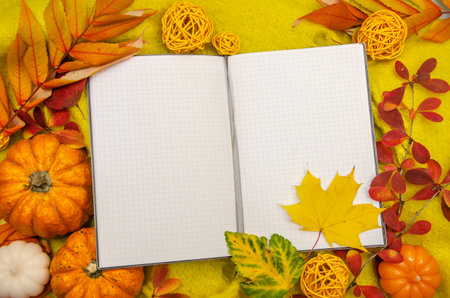 Close-up autumn composition background knitted with workspace planner blank notebook, beautiful red yellow golden leaves. Top view flat lay, copy space, vintage toning. Autumn relax concept copy spaceの写真素材