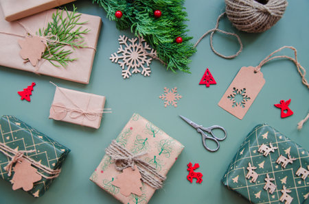 Eco friendly Christmas composition with gift boxes in craft reusable paper and natural decor on blue green background top view. Zero waste environmentally friendly Christmas concept.の写真素材