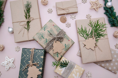 Eco friendly Christmas composition with gift boxes in craft reusable paper and natural decor on white background top view. Zero waste environmentally friendly Christmas concept.の写真素材