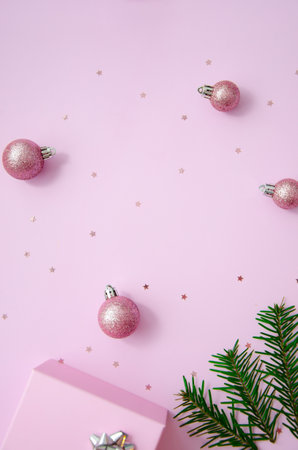 Christmas composition. Pink balls, wooden snowflakes,fir branches, glitter, gift box on pastel pink background. Christmas, winter, new year concept. Flat lay, top view, copy space.