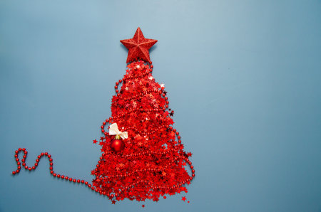 Red glitter fir tree icon with big red star, ribbon and ball, shining glowing twinkled sparkled object, Christmas and New Year invitation celebration card design, festive design element. Copy space.の写真素材