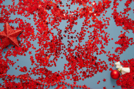 New Year Christmas glitter red star shaped confetti on blue background. Xmas holiday celebration concept. Template mockup greeting card designの写真素材