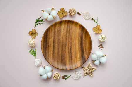 Christmas and new year festive card template on wooden plate with dried flowers, thuja branches, cotton buds and straw stars, top viewの写真素材