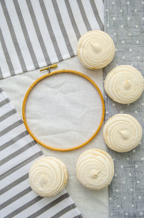 Meringue homemade zephyr marshmallows with round embroidery hoop frame on cotton tablecloth. mockup card. Template for recipes, food menu, craftの写真素材