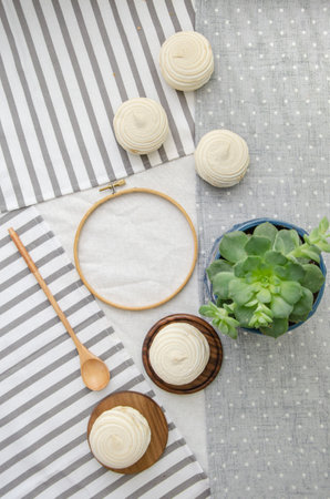Meringue homemade zephyr marshmallows with round embroidery hoop frame, wooden spoon, echeveria plant on cotton tablecloth. mockup card. Template for recipes, food menu, craftの写真素材