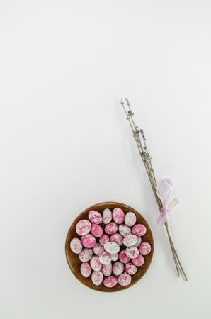 Chocolate easter eggs on a plate and dried lavenders on white background. Copy space. Easter...