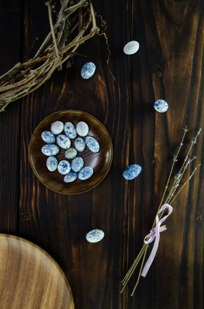 Easter composition. Blue eggs on wooden plate with dried lavender on dark vintage wooden background...