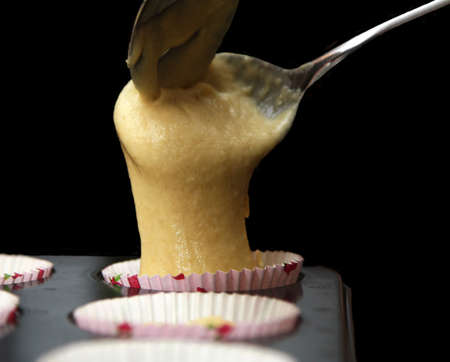 Two spoons in the process of baking a muffinの写真素材