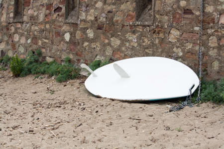 An unused surfboard leaning against the wallの写真素材