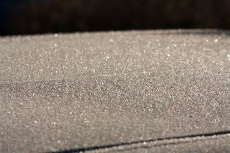 Frozen car roof in the morning sunの写真素材