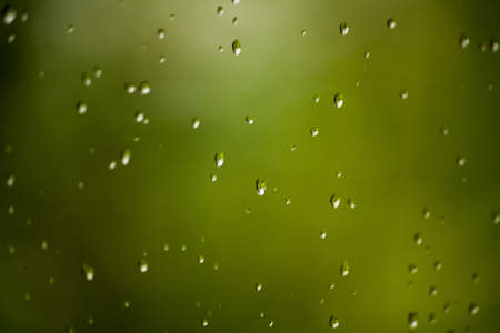Water drops on a window photographed on a rainy day. These raindrops simply look magical.の写真素材