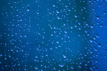 Water drops on a window photographed on a rainy day. These raindrops simply look magical.の写真素材