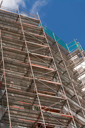 construction scaffolding standing on the side of a buildingの写真素材
