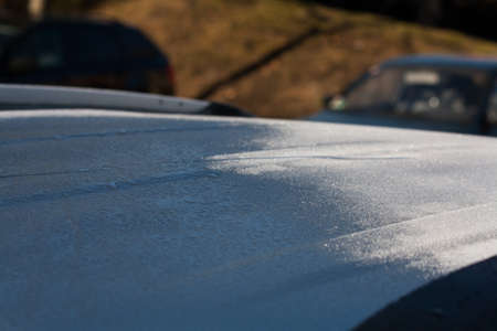 frozen roof of a car in the sun, defrosting & melting in the sunの写真素材