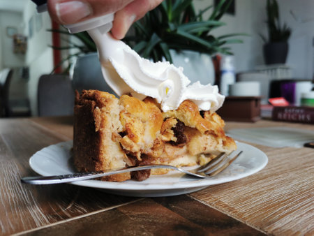 Dutch apple pie, baked following grandma's recipe, getting some whipped cream on top.の写真素材