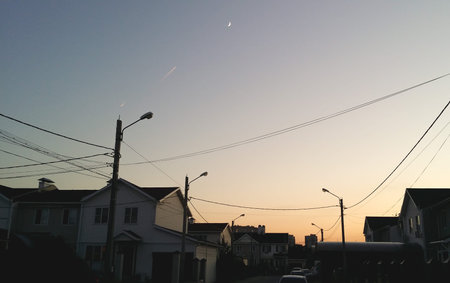 two military fighter fly on background of the moon crescent. condensation trail illuminated rays of the setting sun. country village.の写真素材