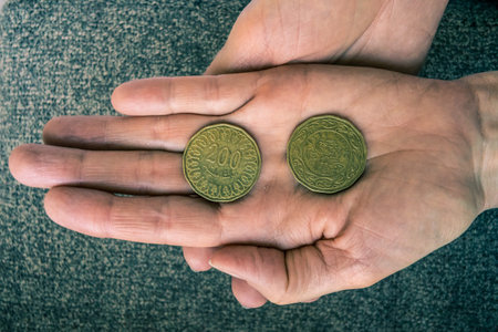 Two Tunisian coins on the woman's palm.