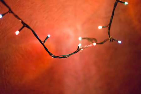 Christmas lights on red background, shallow focus