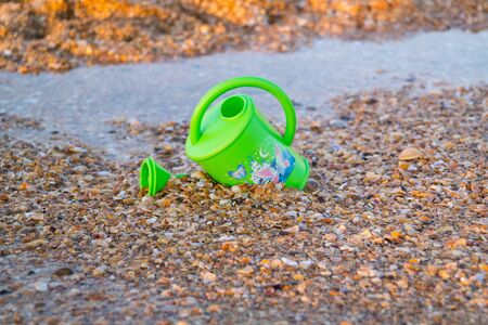 Children's toy for watering flowers on the beachの写真素材