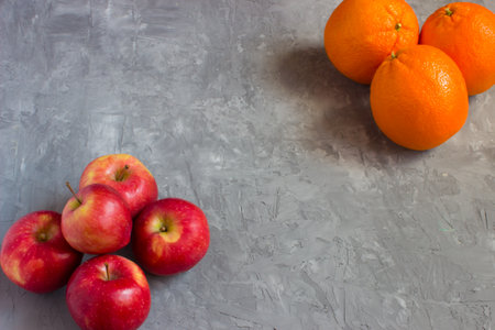 Oranges and apples on a grey concrete background with copyspaceの写真素材