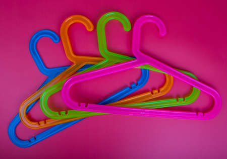 Colored plastic hangers on red background. Storage and sales conceptの写真素材