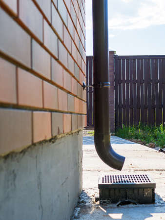 View of the storm drain pipe installed on the brick wall of a private house.の写真素材