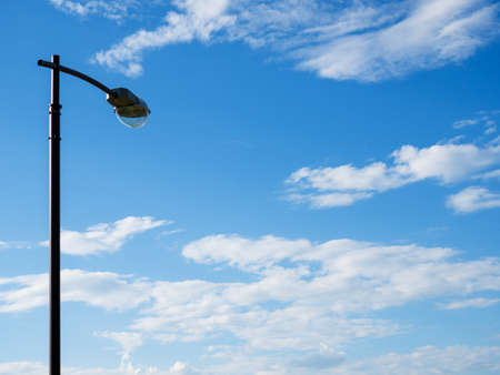 The street lighting pole against the background of a blue sky with clouds.の写真素材
