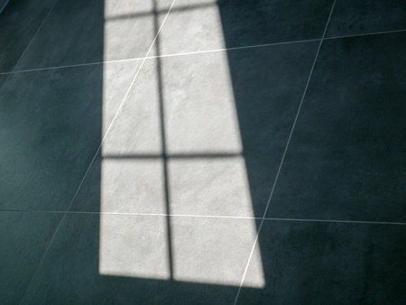 The shadow of the window falling on the floor of gray concrete tiles.の写真素材