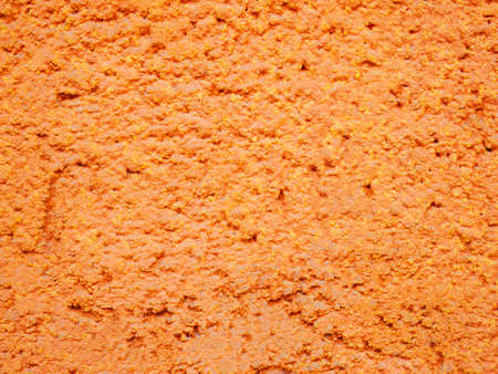 The background is made of a bright orange wall with a coating of mounting foamの写真素材