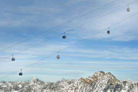 Winter Holiday Gondola Ski Lift Above Alps Mountainsの写真素材