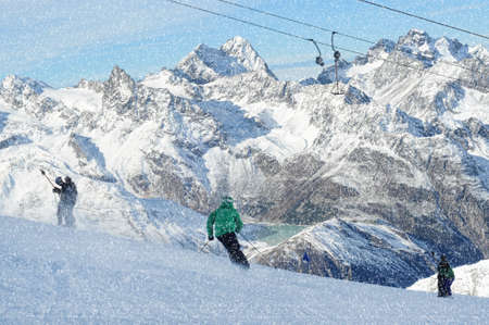 T bar ski lift pulling skiers up the slope. Skier skiing down the slope. Snowy winter in European Alps.の写真素材