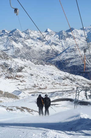 .T bar ski lift pulling two skiers up the slope. Beautiful mountain landscape.. Perfect winter in European Alps.の写真素材