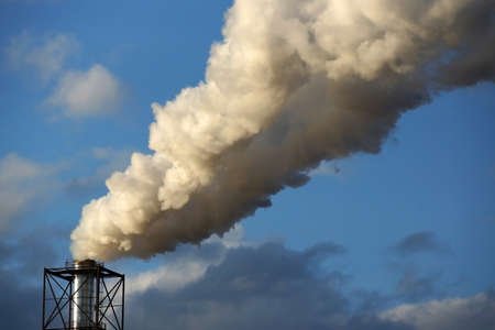 smoke from a chimney on a blue skyの写真素材