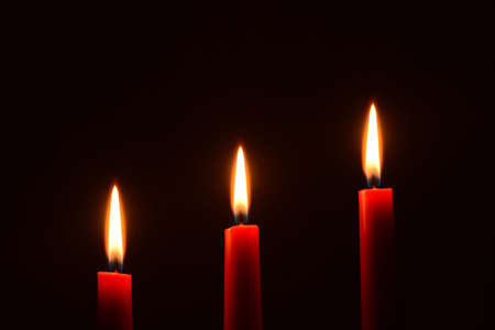 Three red candles on a black backgroundの写真素材