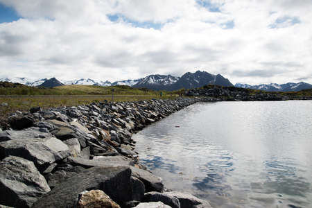 waterside with boulders over mountains, Lofoten Islandsの写真素材