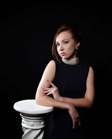 elegant woman standing near pillarの写真素材