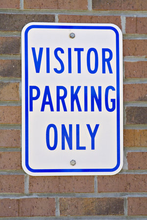 Just Visiting sign mounted on brick wall.の写真素材