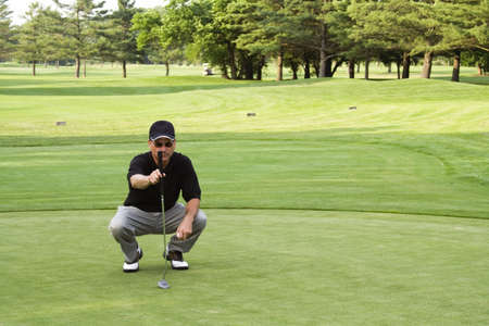 Male golfer plumbing the next putt.  Not sharpened in camera or when converted from RAW.の写真素材