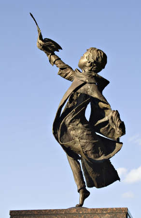 Beautiful statue of a boy releasing a bird.  Located in a public park and cemetery.の写真素材