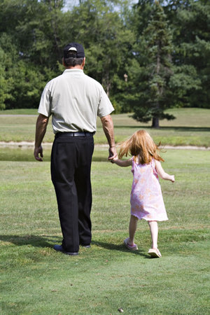 A grandfather or father walking daughter in a park.の写真素材