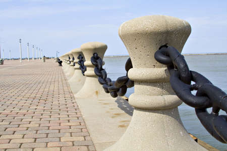 A Cleveland dock borders on Lake Erie - cement pier posts with large iron chain.の写真素材