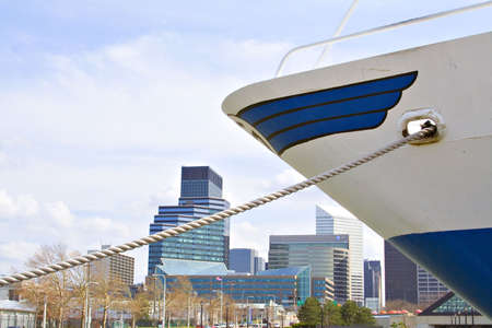 A large ship anchored and tied off the Cleveland shore.  Downtown skyscrapers in the background. の写真素材