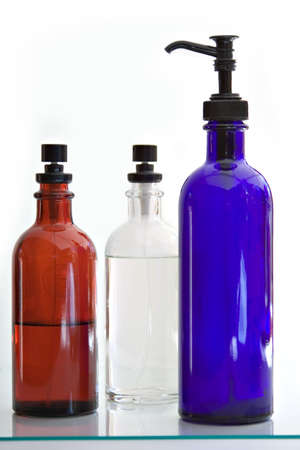 Two spray (fragrance) and one lotion bottle.  Colored glass.の写真素材