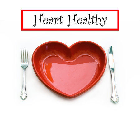 A heart health concept - isolated on white - red heart plate, knife and fork with text banner graphic.の写真素材